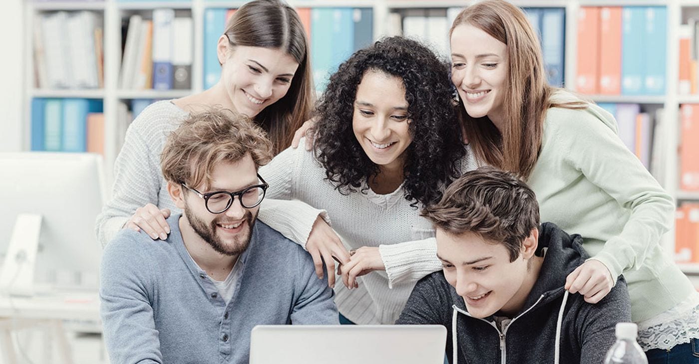 Students working through an assignment together on a laptop